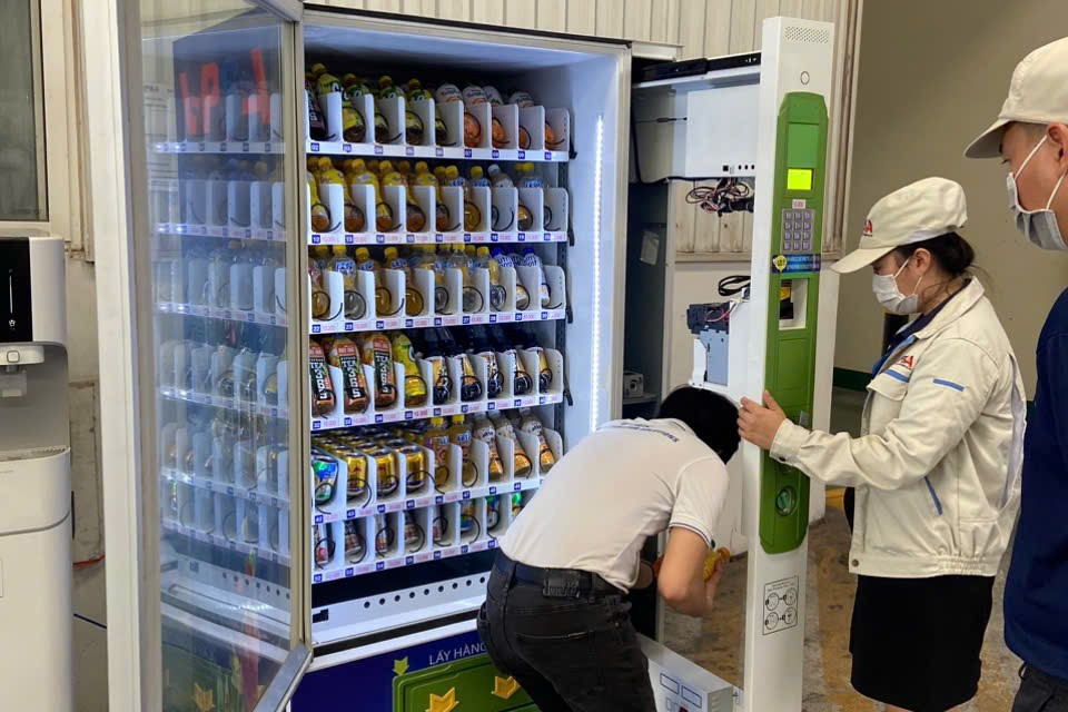 nhân viên bảo trì đnag bảo trì máy bán hàng tự động