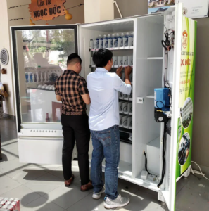 Kỹ thuật viên đang vệ sinh và kiểm tra cảm biến trong máy bán hàng tự động."